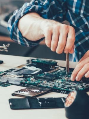 Computer repair shop. Engineer performing laptop maintenance. Hardware developer fixing electronic components. PC technology